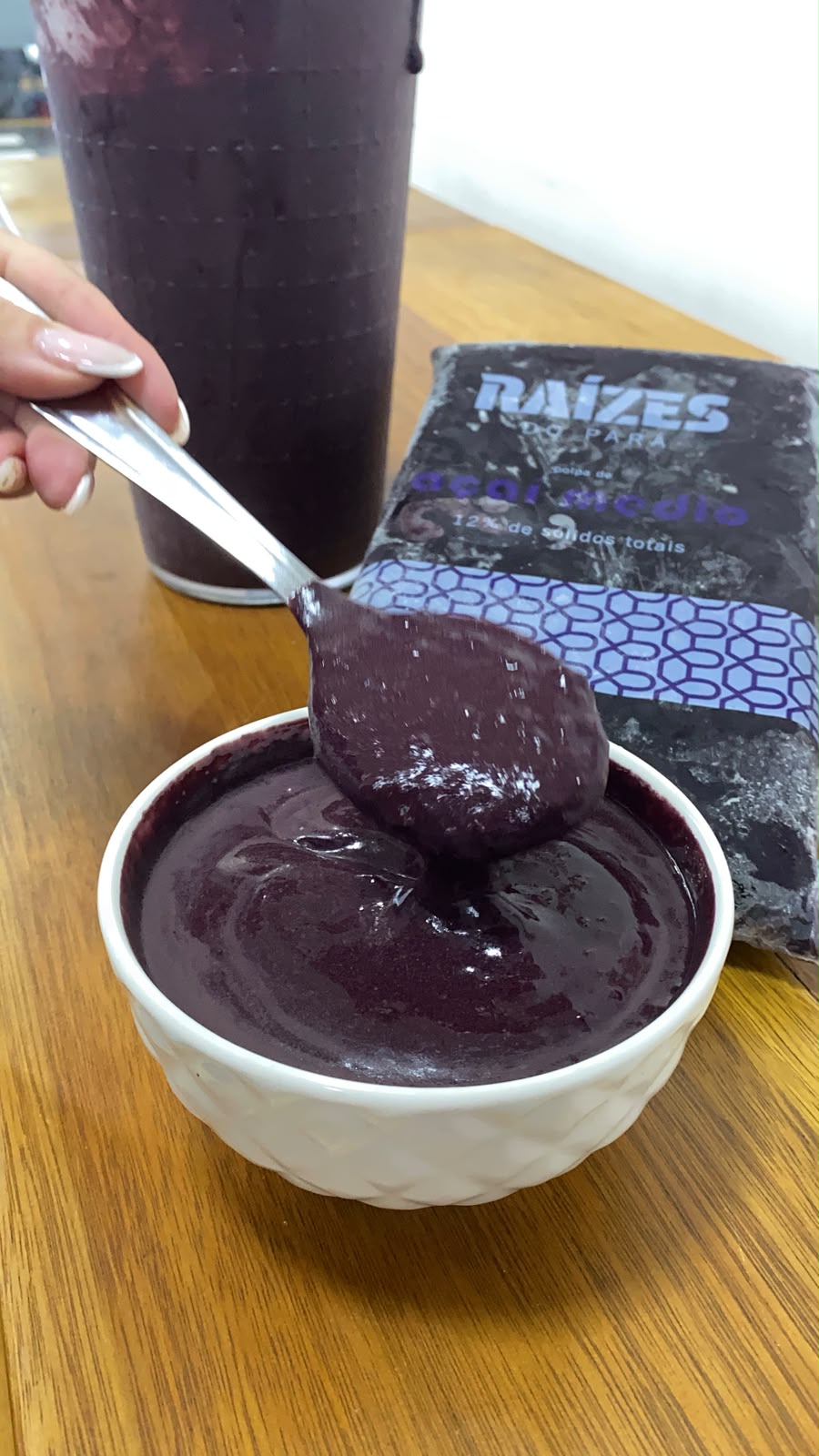 Colher levantando açaí puro e encorpado de uma tigela branca